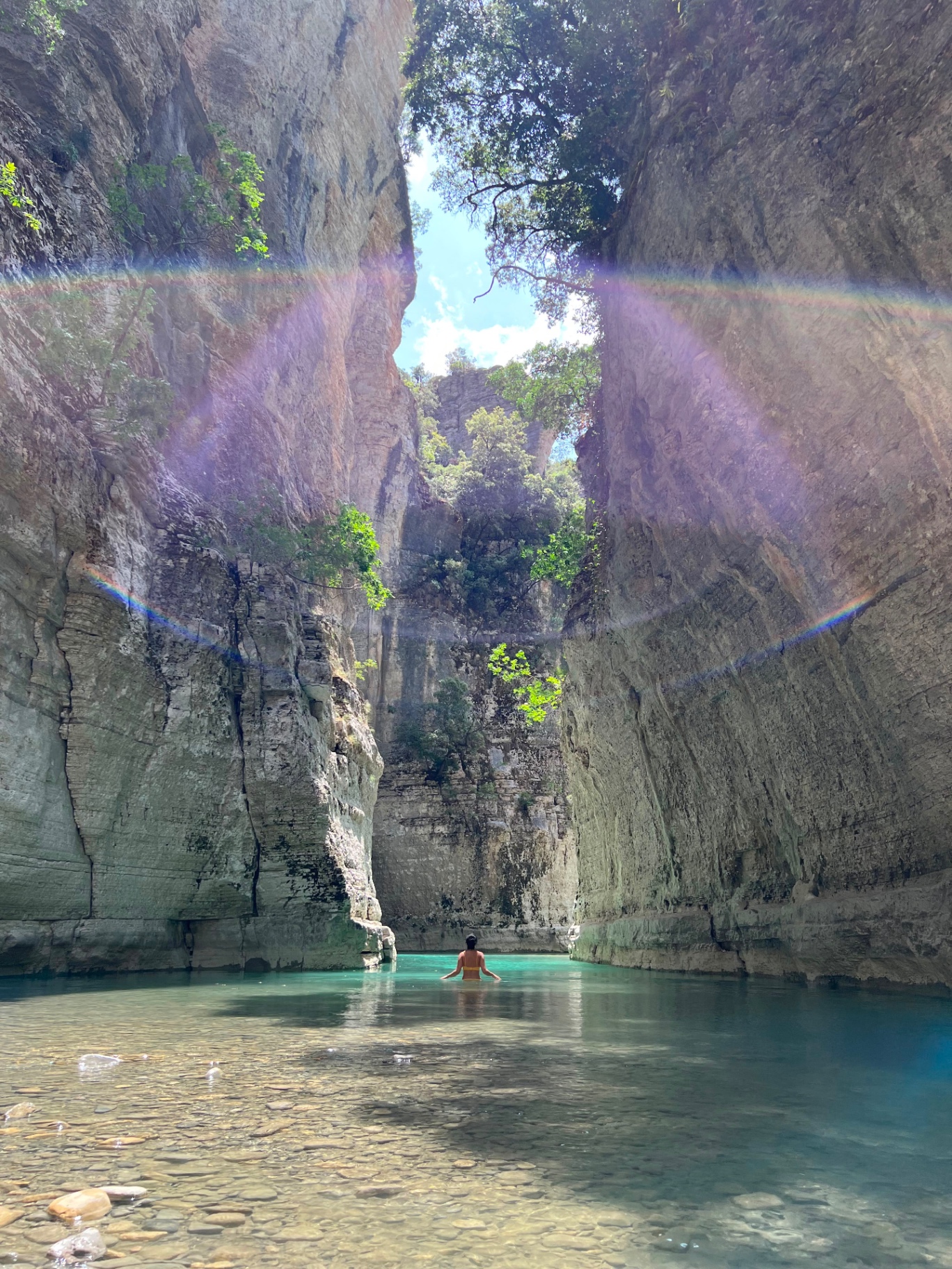 Bogova Waterfall cascading into a turquoise pool with sun rays
